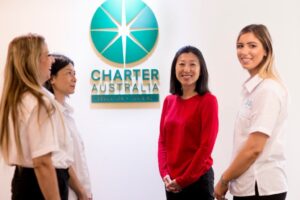 チャーターオーストラリアのロゴを前にする学生たち