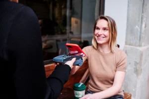 カフェでスマホで支払いする女性